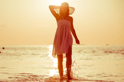 海辺で水遊びする女性